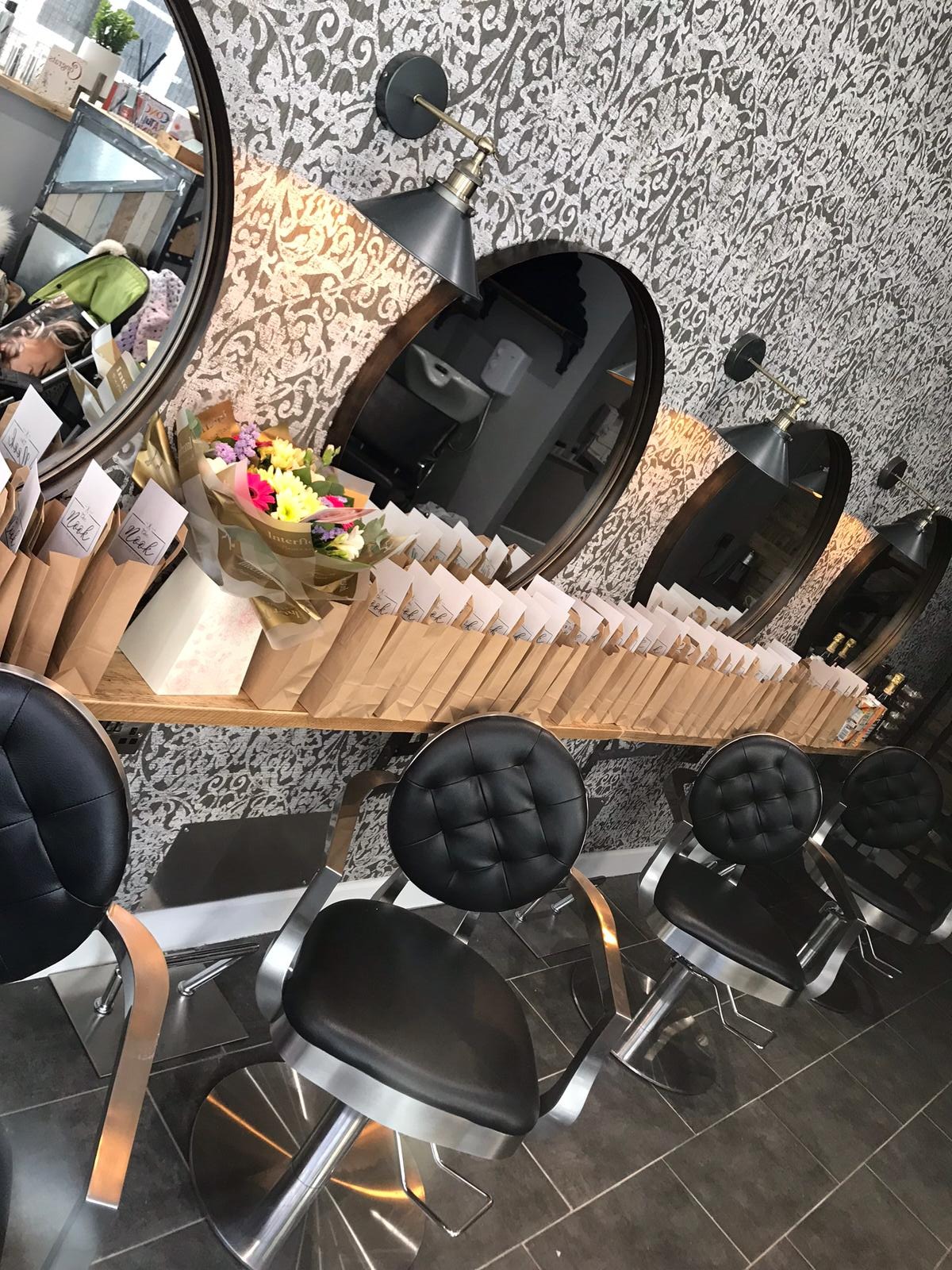 Styling stations with round mirrors and black buttoned chairs